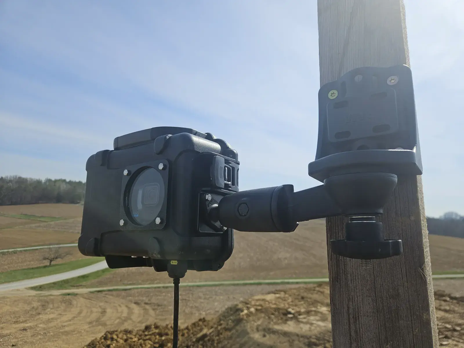 Camera pole-mounted at the edge of a field site
